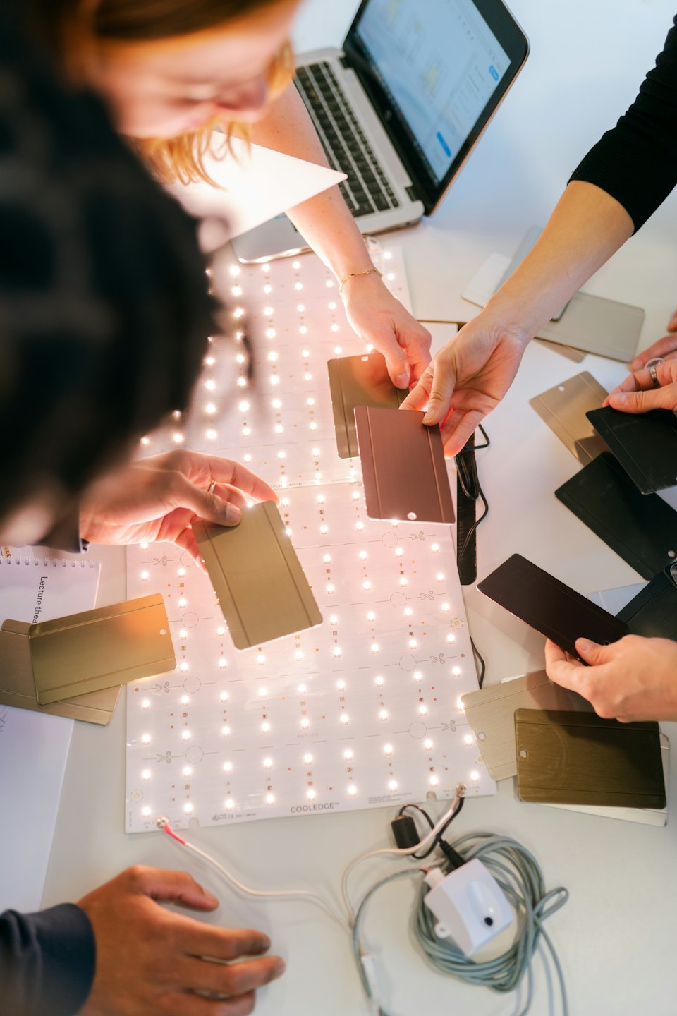 Equipo colaborando con muestras de color bajo luz LED.