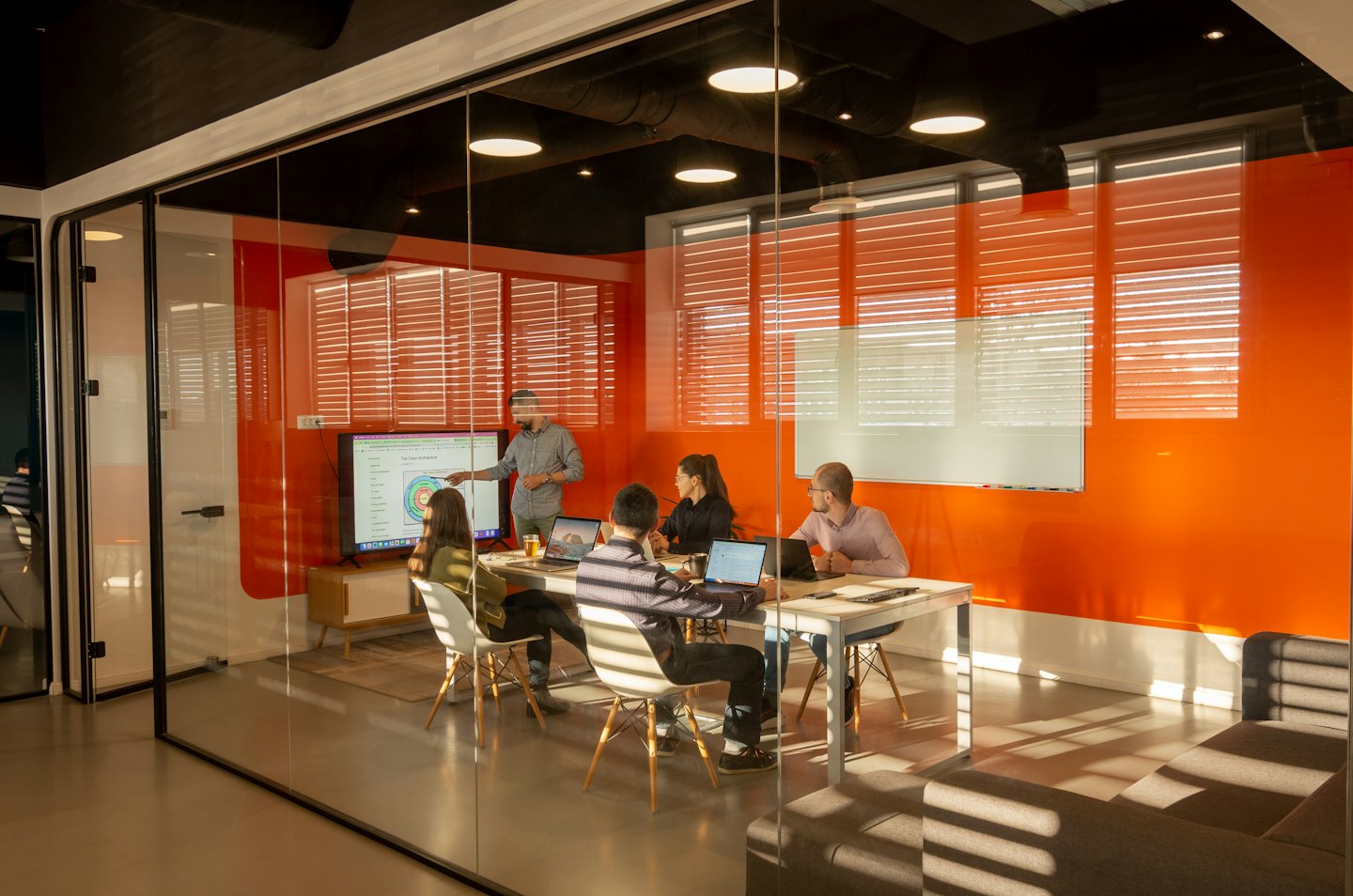 Equipo de negocios reunido en una sala de conferencias moderna con pantalla.